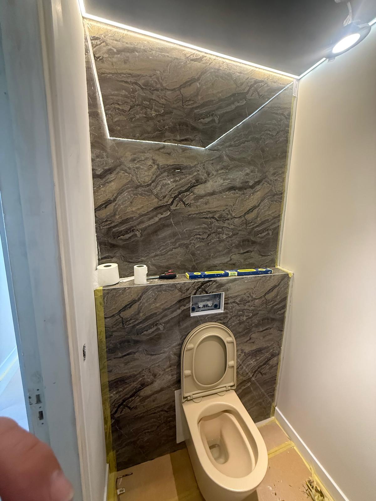 Gerenoveerd toilet met steenlook wand en LED verlichting